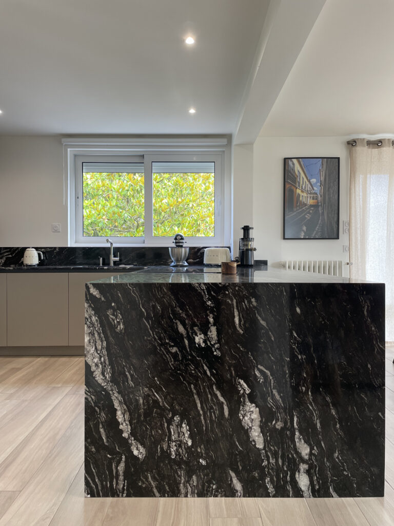 Îlot central en pierre naturelle granit Titanium, conçu par MS Singulier à Paris pour une cuisine moderne et élégante.